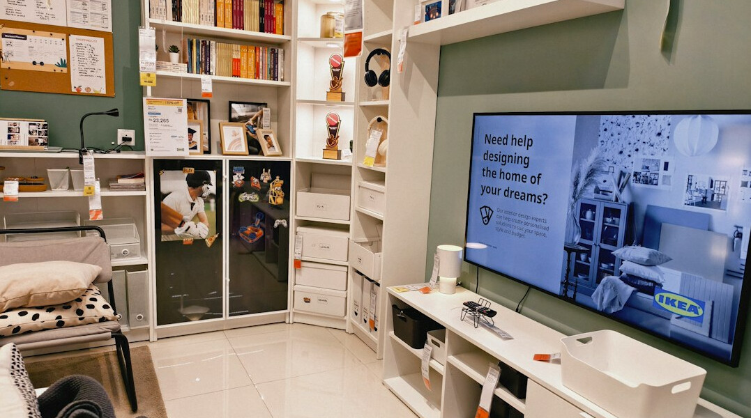 Editorial office with tall bookshelves, a wooden desk and a green desk lamp